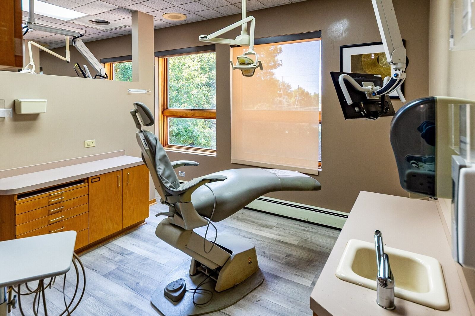 Dental operatory with a window onto mature trees at 7515 W Yale Ave, Denver