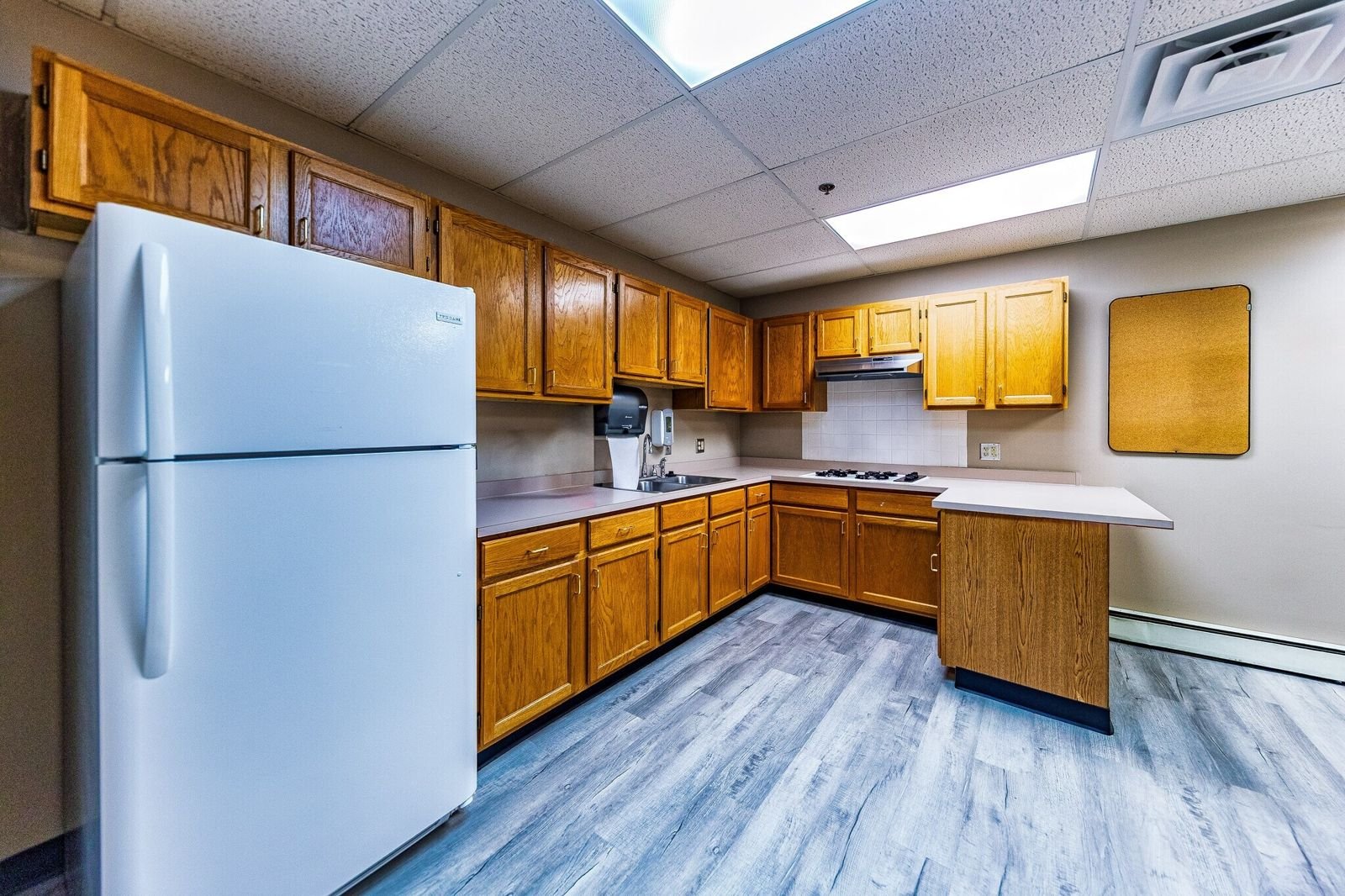 Staff breakroom with oak cabinets at 7515 W Yale Ave, Denver